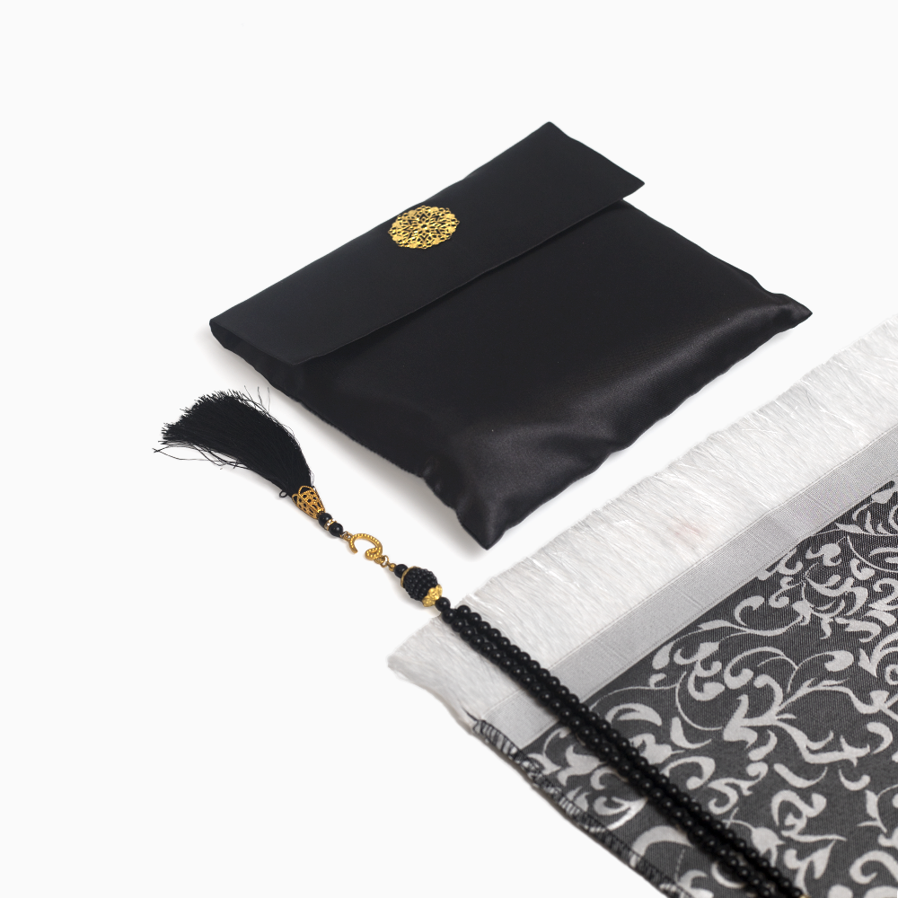 a black prayer mat with its pouch and a matching black prayer bead