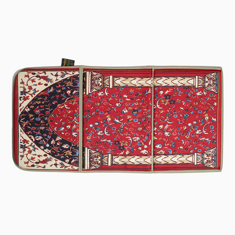 full view of a lava red portable prayer rug lying on the ground
