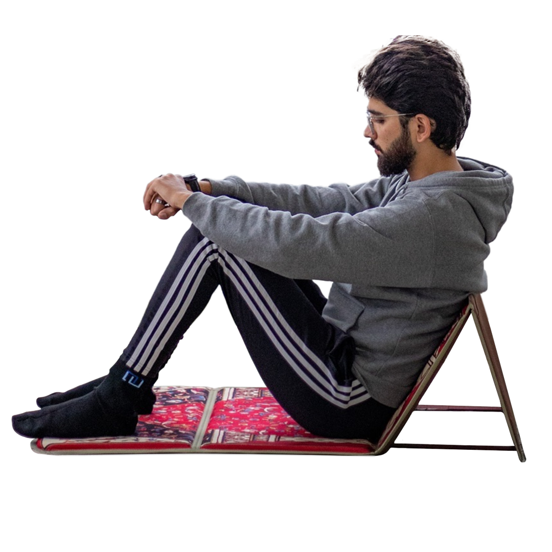 a boy sitting with the help of backrest of an ebadat prayer rug in lava red color