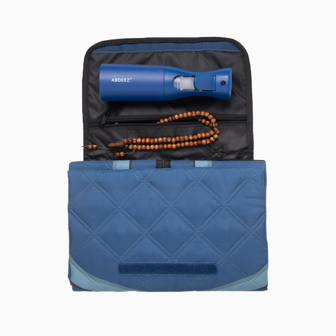 Blue prayer mat with a wudhu spray and prayer beads