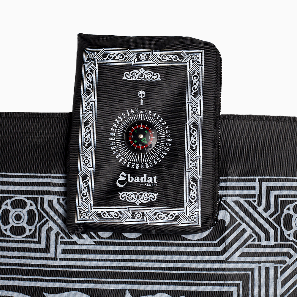 An image of black portable prayer mat with the top-down view