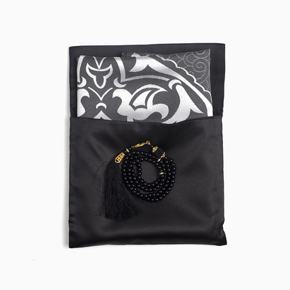 black colored prayer rug placed in its carrying pouch and black prayer bead placed over it