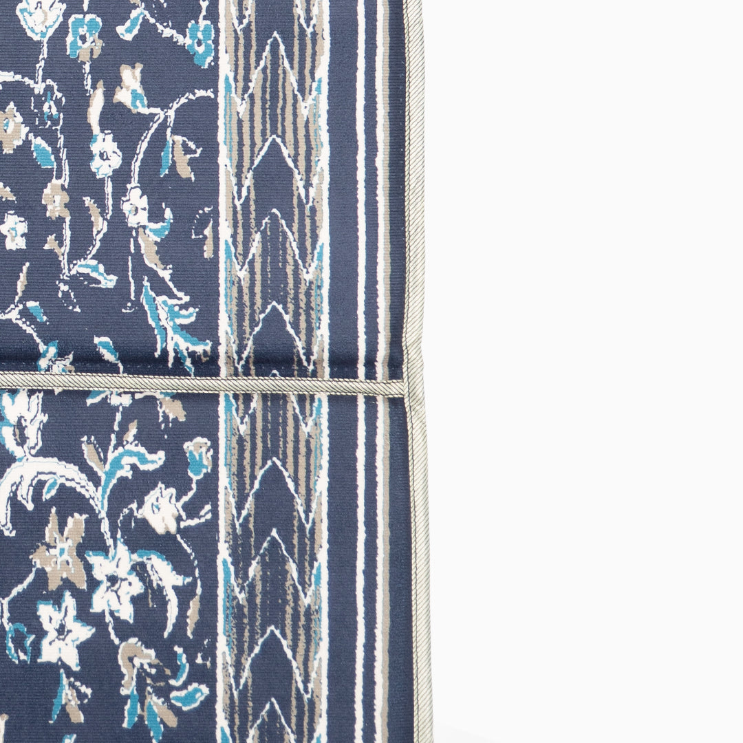 Blue fabric with floral and geometric patterns with a close view