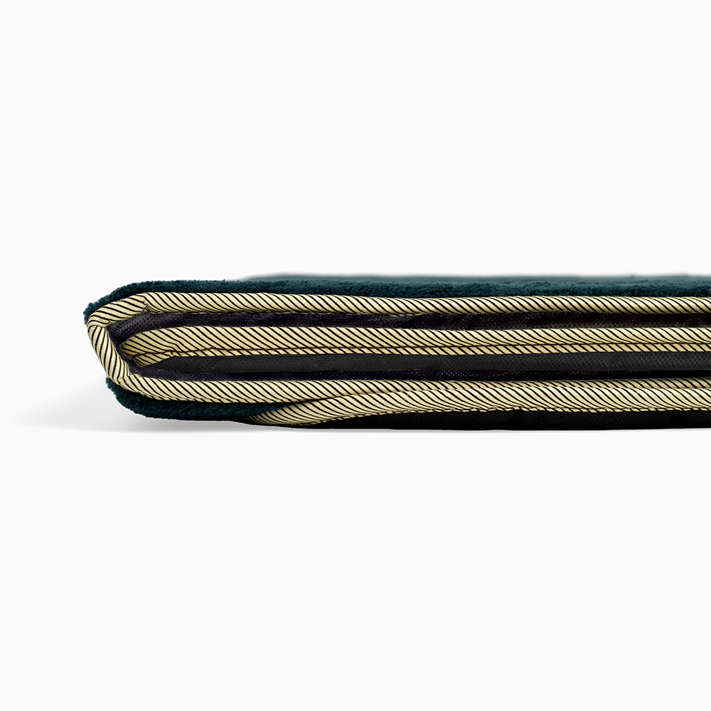 a close up view showing the stitching on a dark emerald green color prayer rug