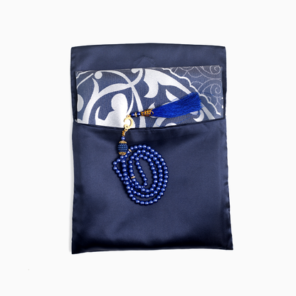 blue prayer mat folded and placed in its pouch with a blue prayer bead placed overr it