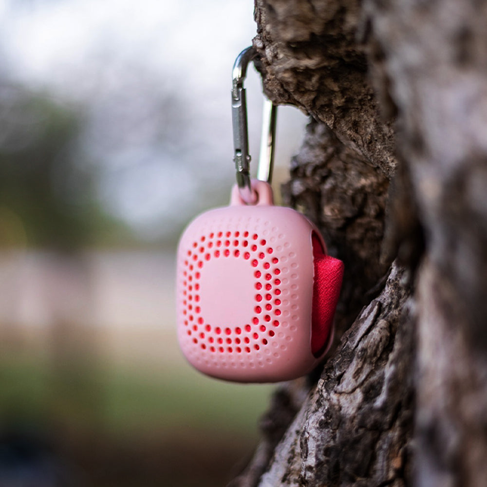 pink wudhu towel hanging via hook with tree in an outdoor setting