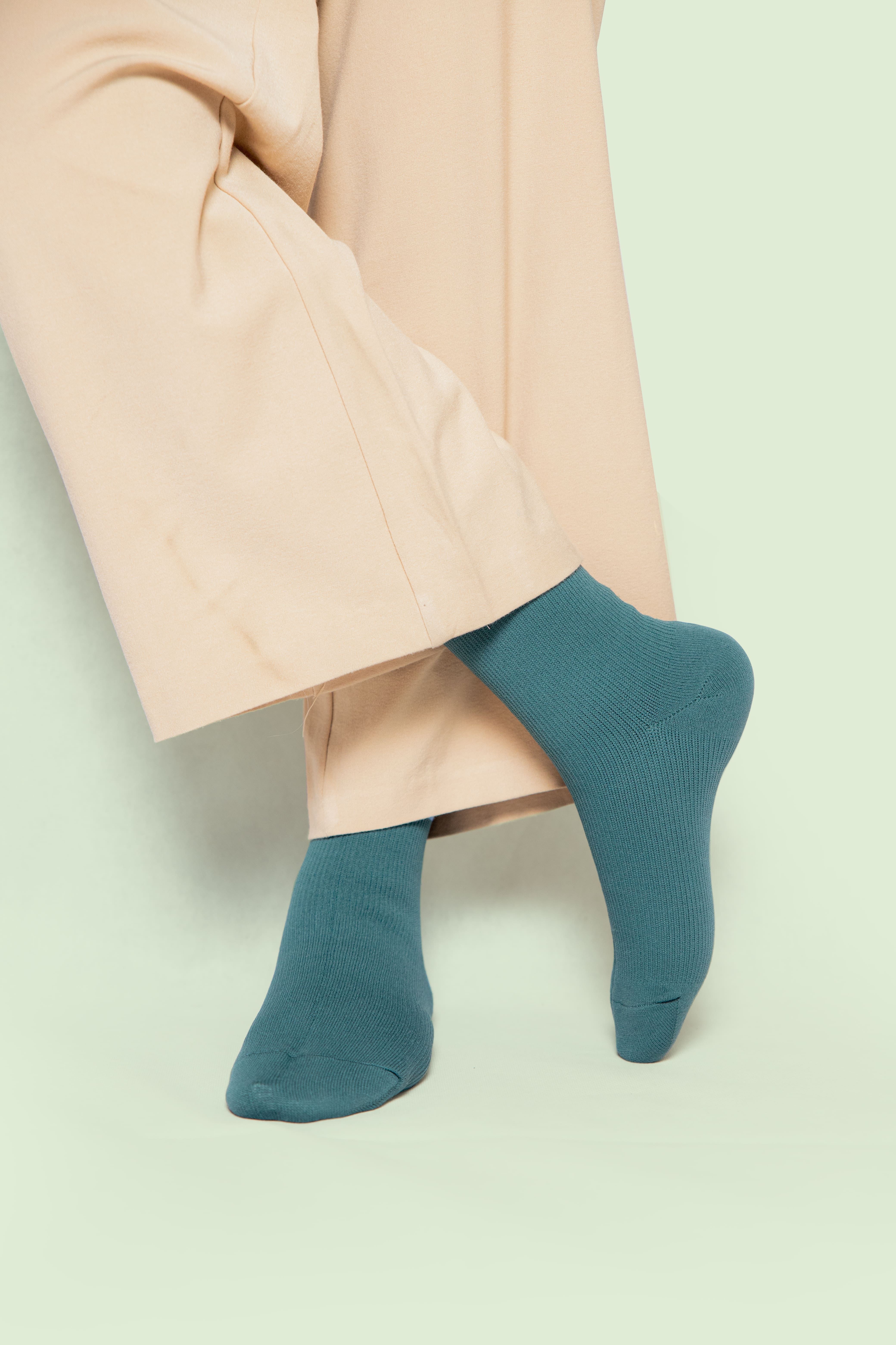 a woman in skin trousers wearing teal blue socks