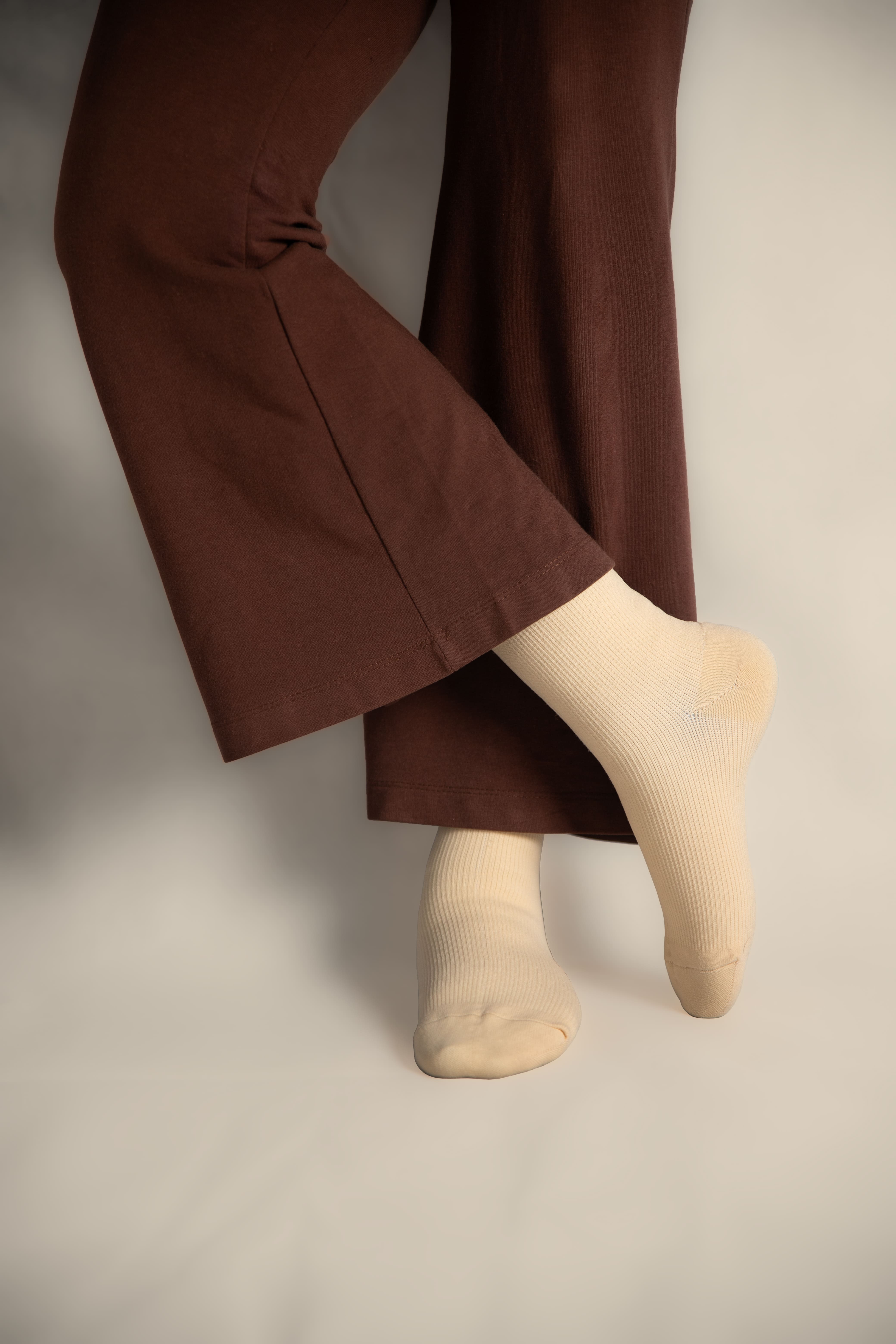 a woman in brown trousers wearing soft ivory socks