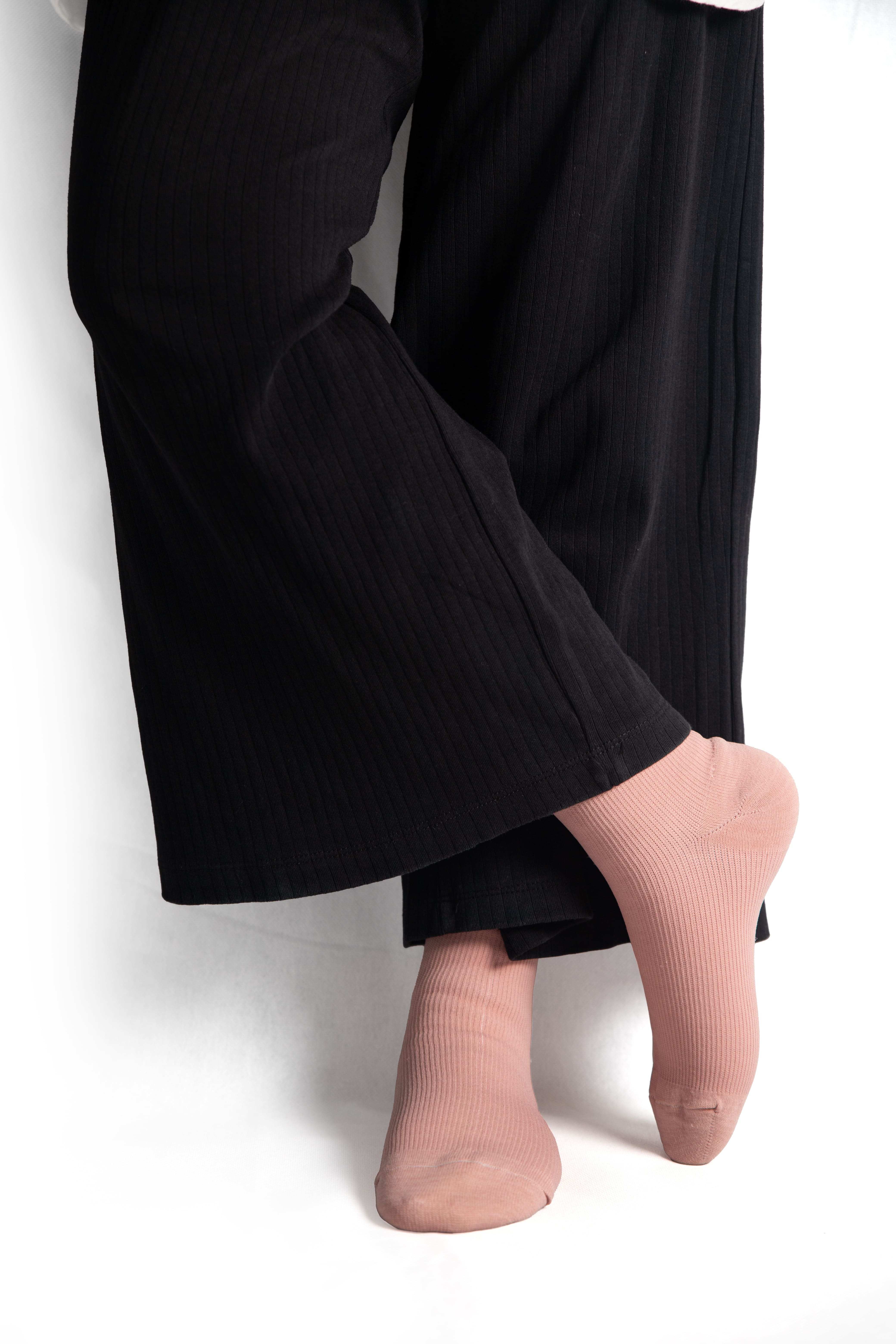 a woman in black trousers in tea pink wudhu socks