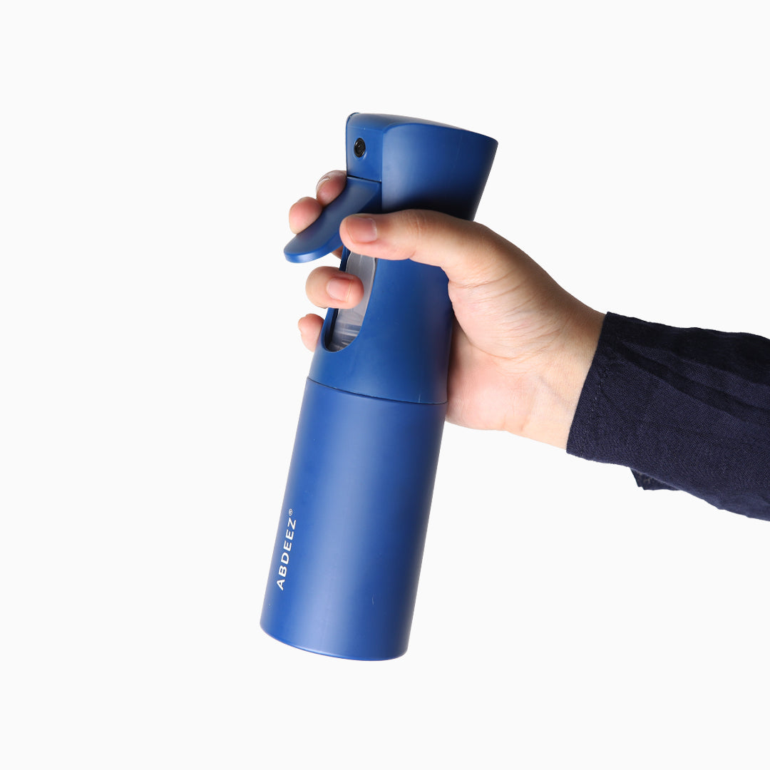 Hand holding a blue wudhu spray bottle